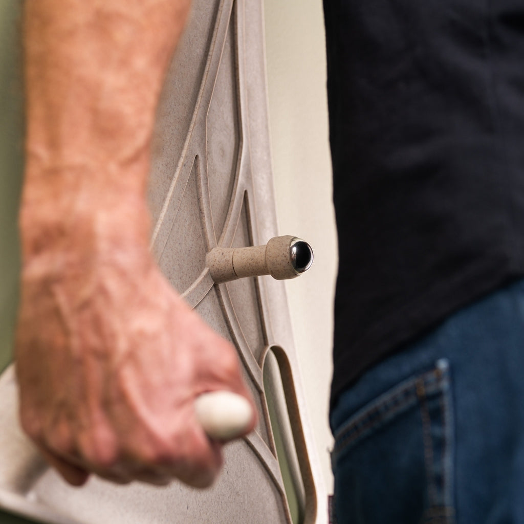 Close up of a man using the Reliefboard against a wall.