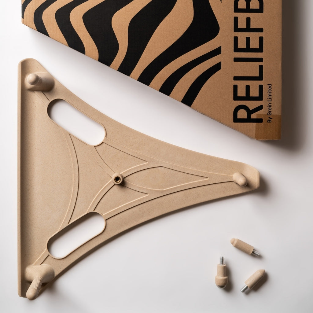 The Reliefboard shown with all its component parts, the Round peg fitted to the top attachment point. Shown on a white background with its branded box next to it.